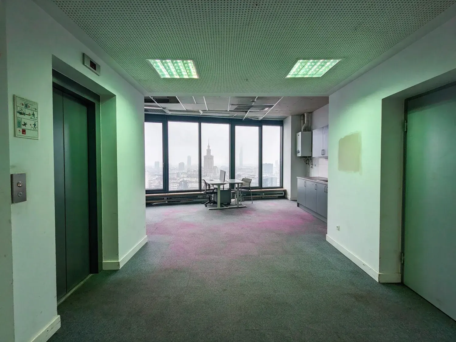 Before and after of a warsaw tower floor shot on a grey february afternoon with the windows blown out and the room three stops down — original listing photo before editing