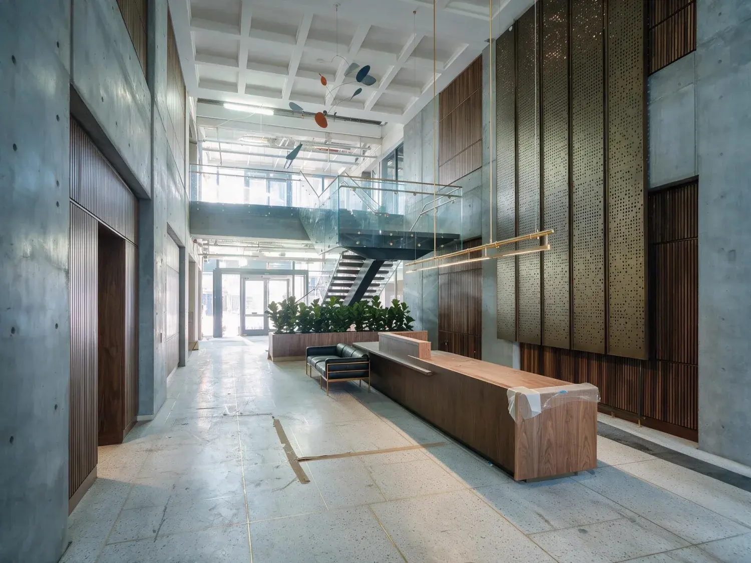 Before and after of a soma tech-hq arrival lobby recovers its true depth of concrete, walnut, and natural light from a muddy pre-construction capture — enhanced by Plotpane