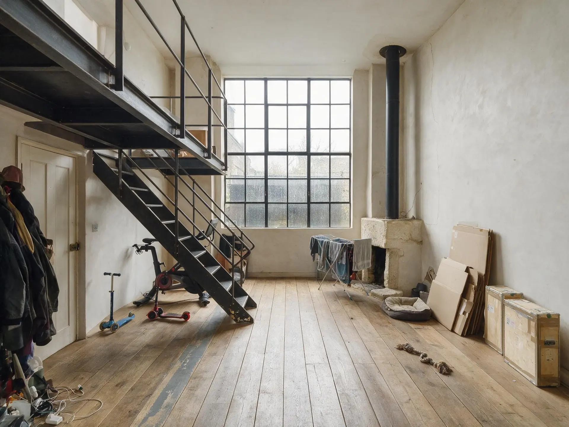 Before and after of a double-height Chelsea studio house in London with household clutter removed. — original listing photo before editing