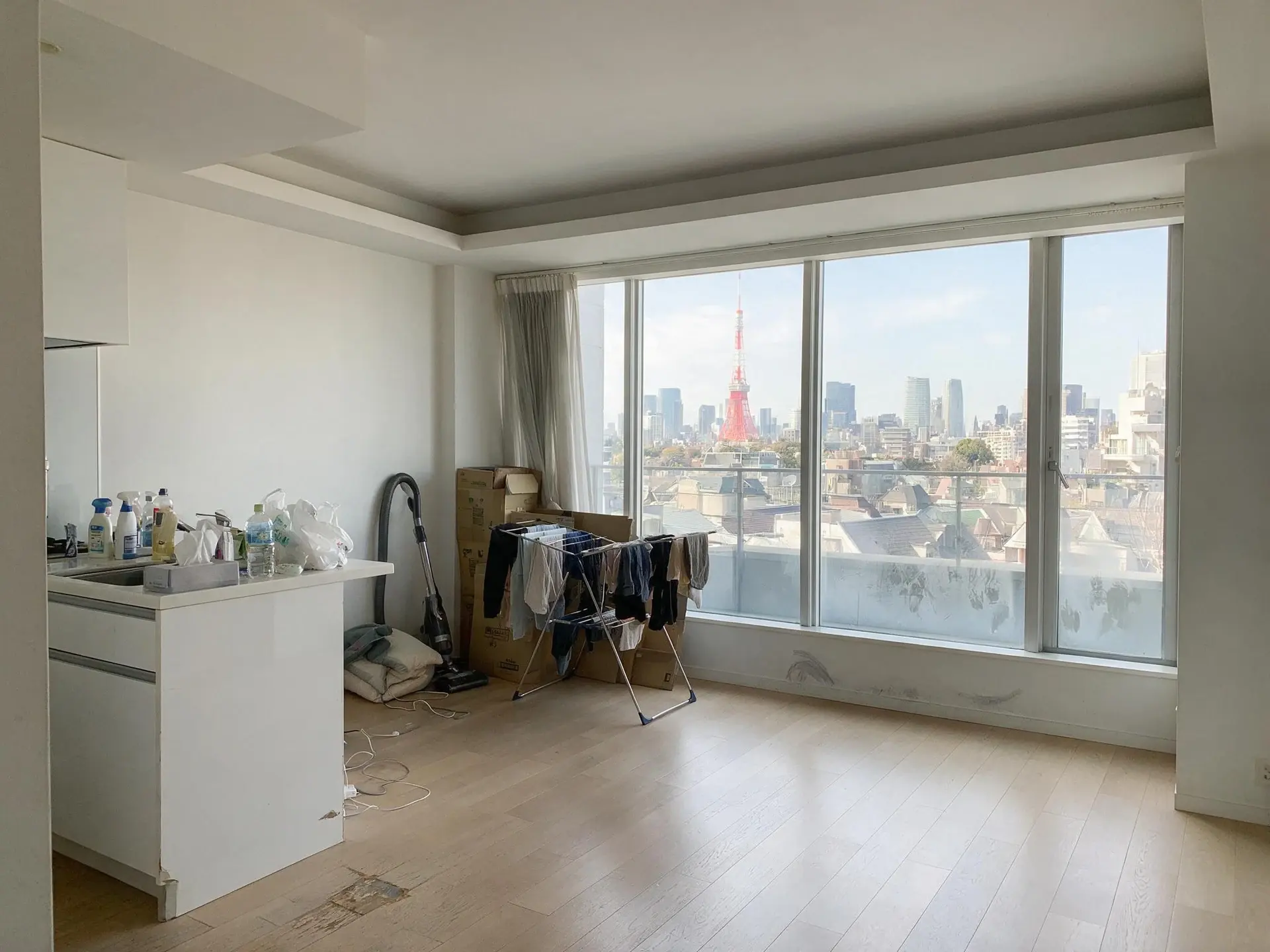 Before and after of a tower residence living room in Azabu, Tokyo, with clutter removed. — original listing photo before editing