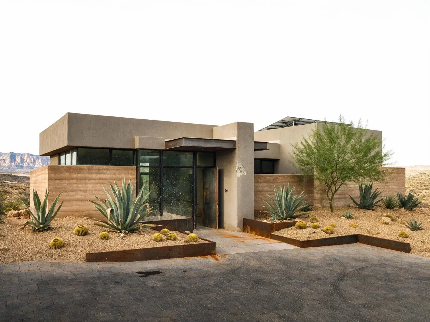 Before and after of front exterior of a summerlin the ridges desert-modern estate with a blown-out white mojave sky replaced by natural nevada desert blue while preserving the red rock escarpment silhouette — original listing photo before editing