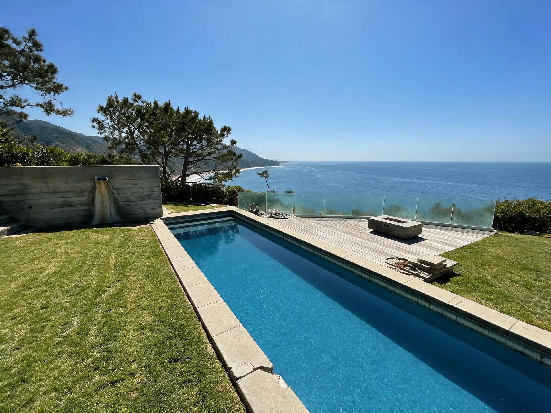 Before and after of an ocean-facing pool and lawn at a bluff-top estate on Point Dume, Malibu. — enhanced by Plotpane