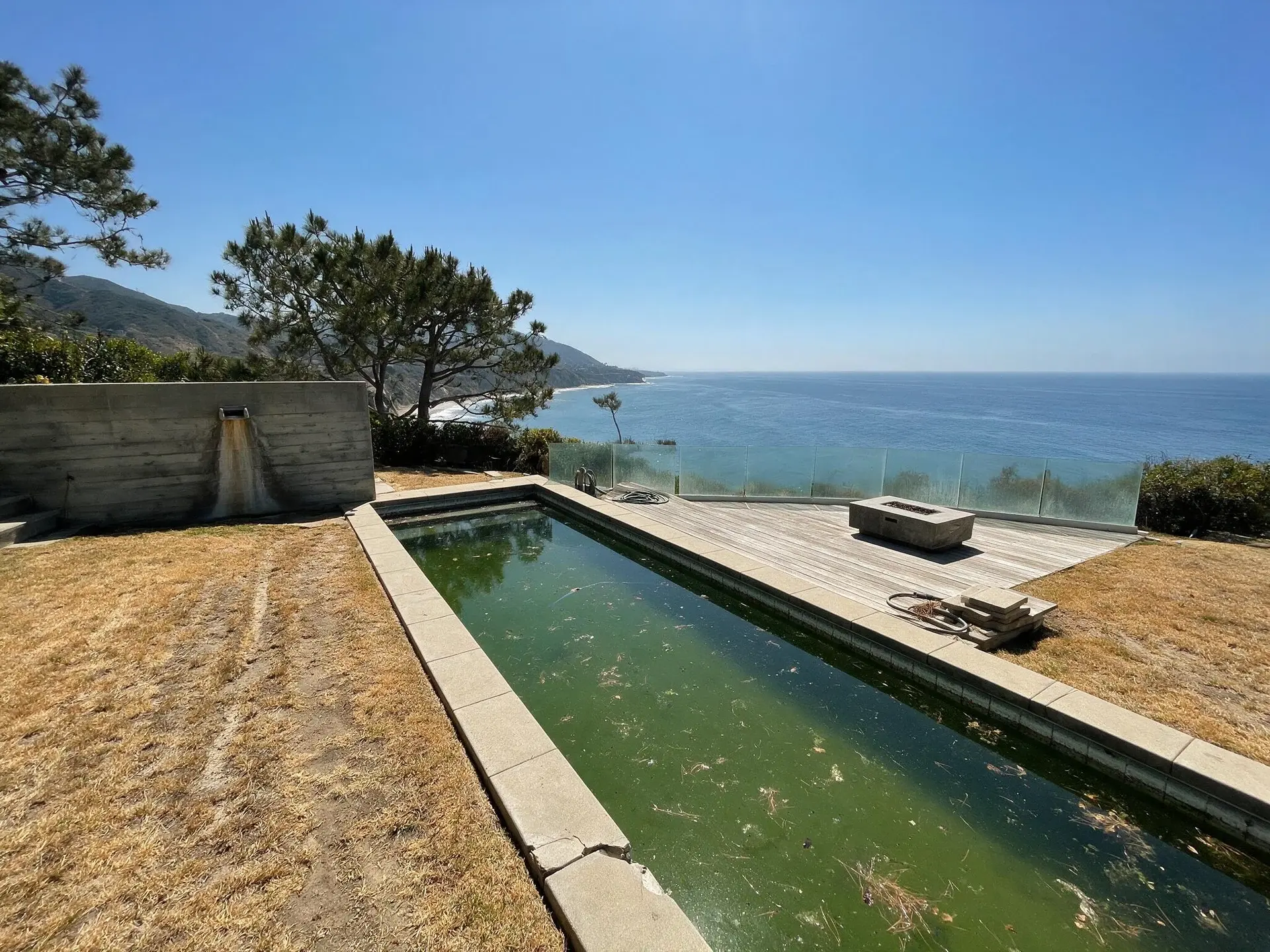 Before and after of an ocean-facing pool and lawn at a bluff-top estate on Point Dume, Malibu. — original listing photo before editing