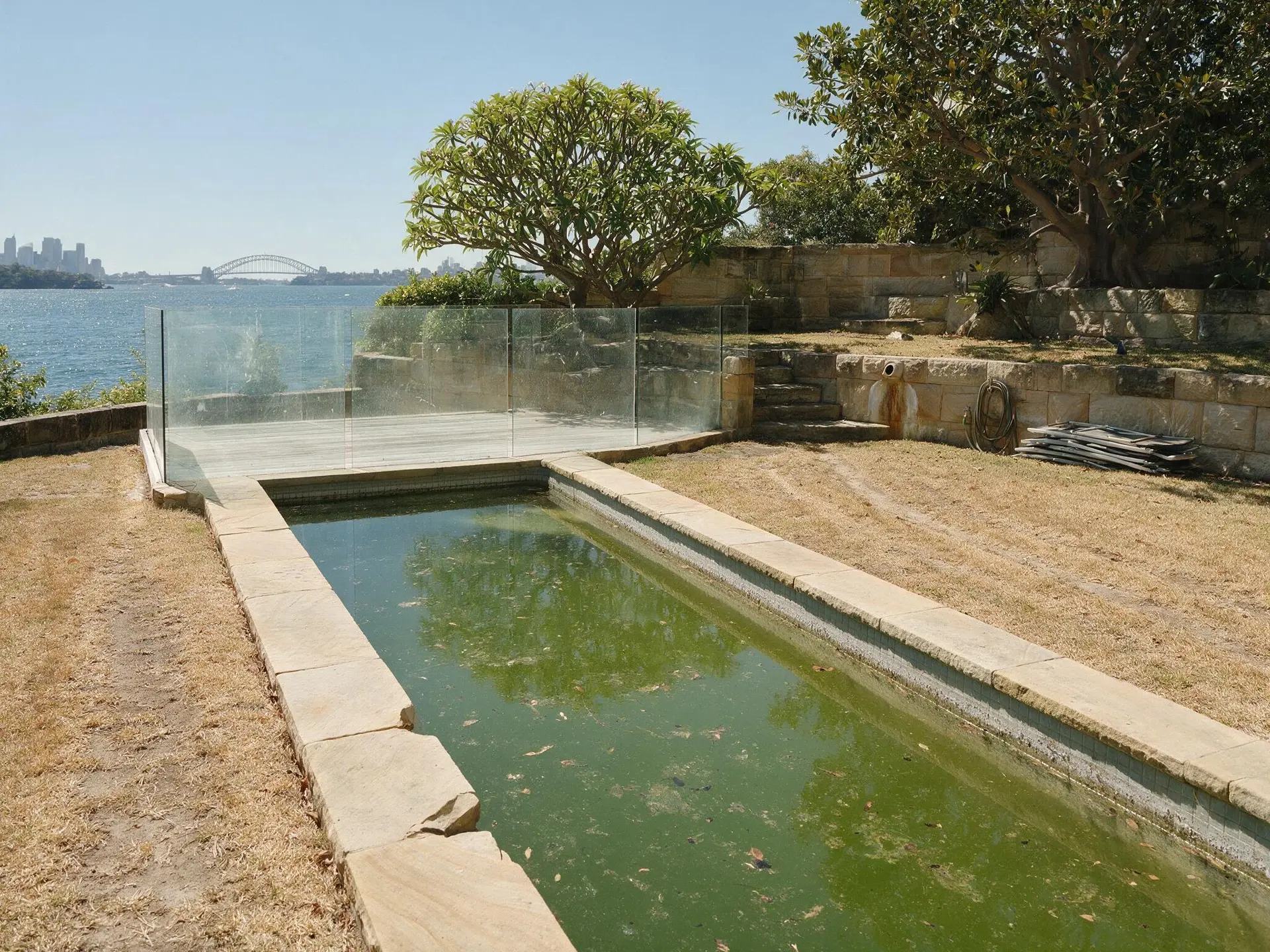 Before and after of a terraced pool and lawn at a harbourfront house in Point Piper, Sydney. — original listing photo before editing