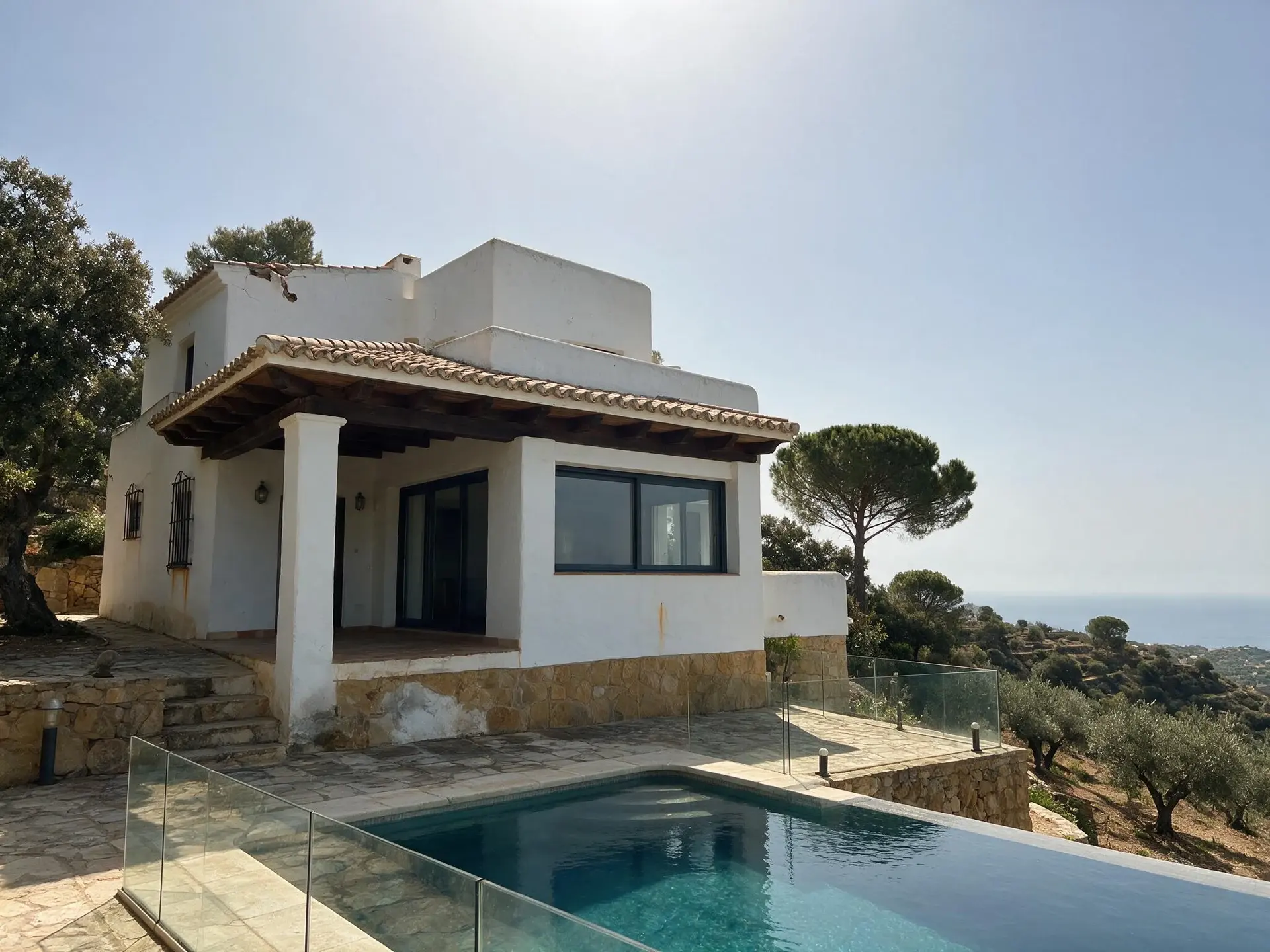 Before and after of a hillside villa exterior in La Zagaleta, Marbella, converted to golden-hour dusk. — original listing photo before editing