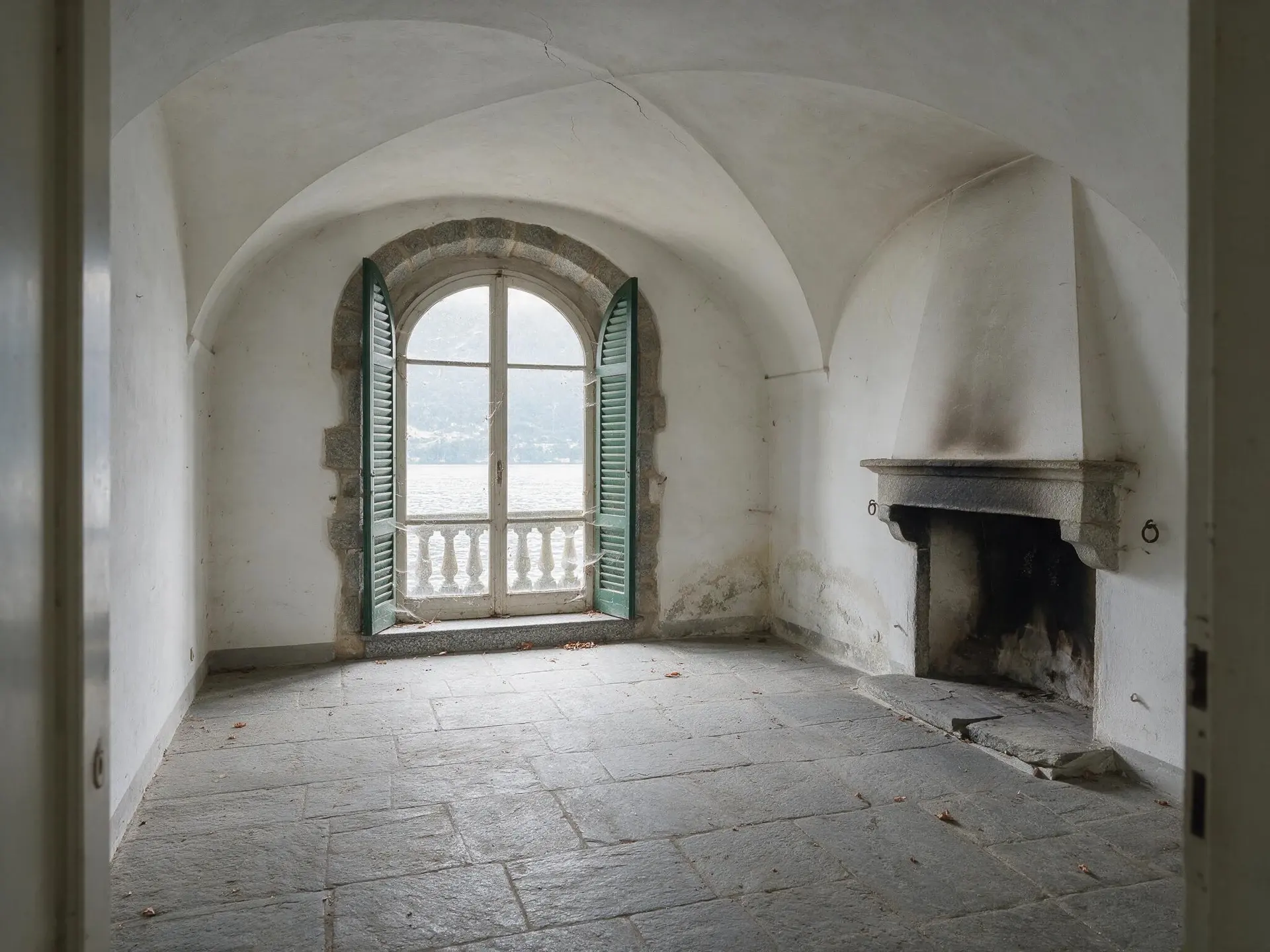 Before and after of an empty vaulted ground-floor room in Menaggio, Lake Como, furnished by virtual staging. — original listing photo before editing