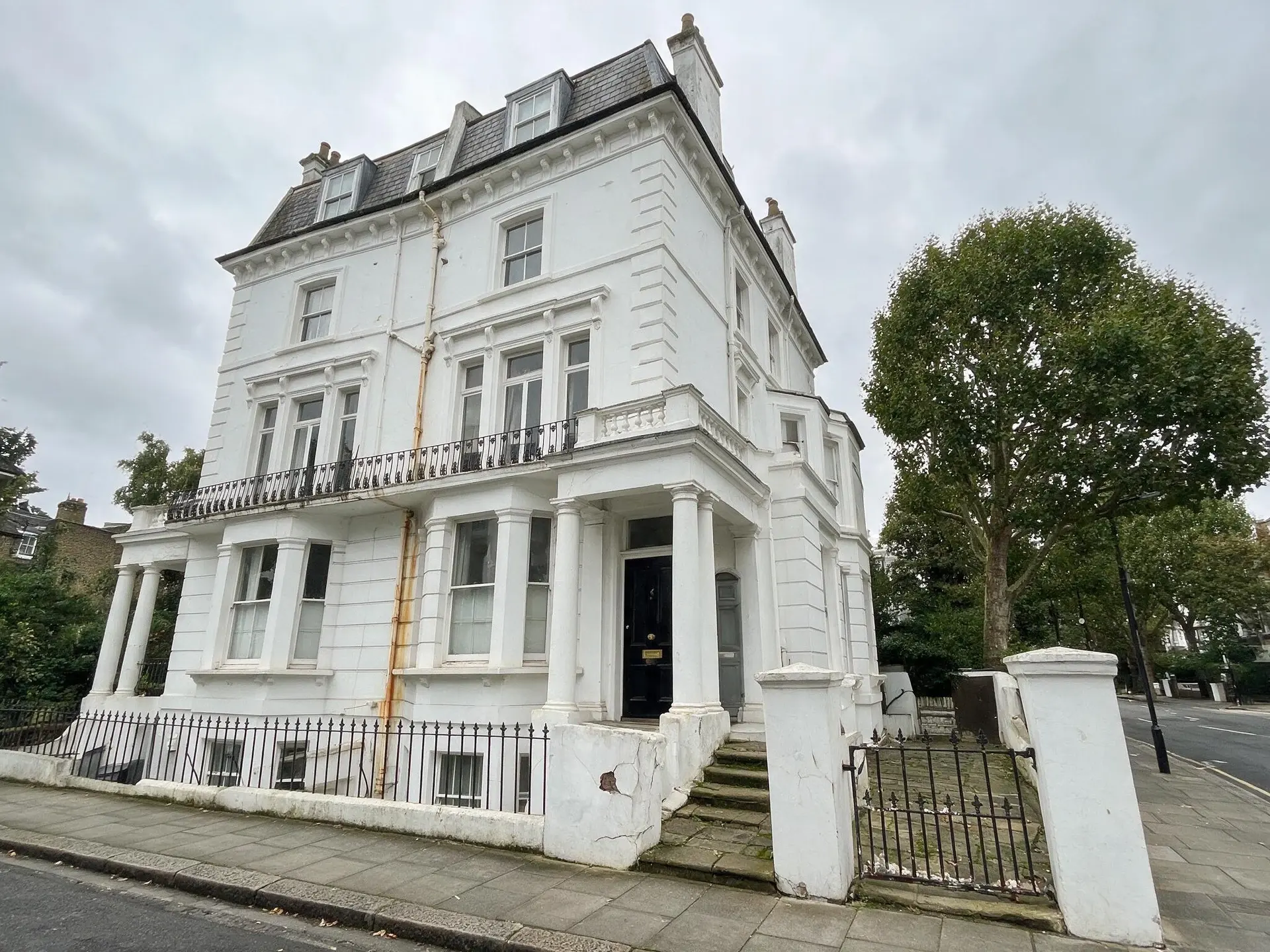Before and after of a white-stucco Notting Hill villa in London with leaning verticals straightened. — original listing photo before editing