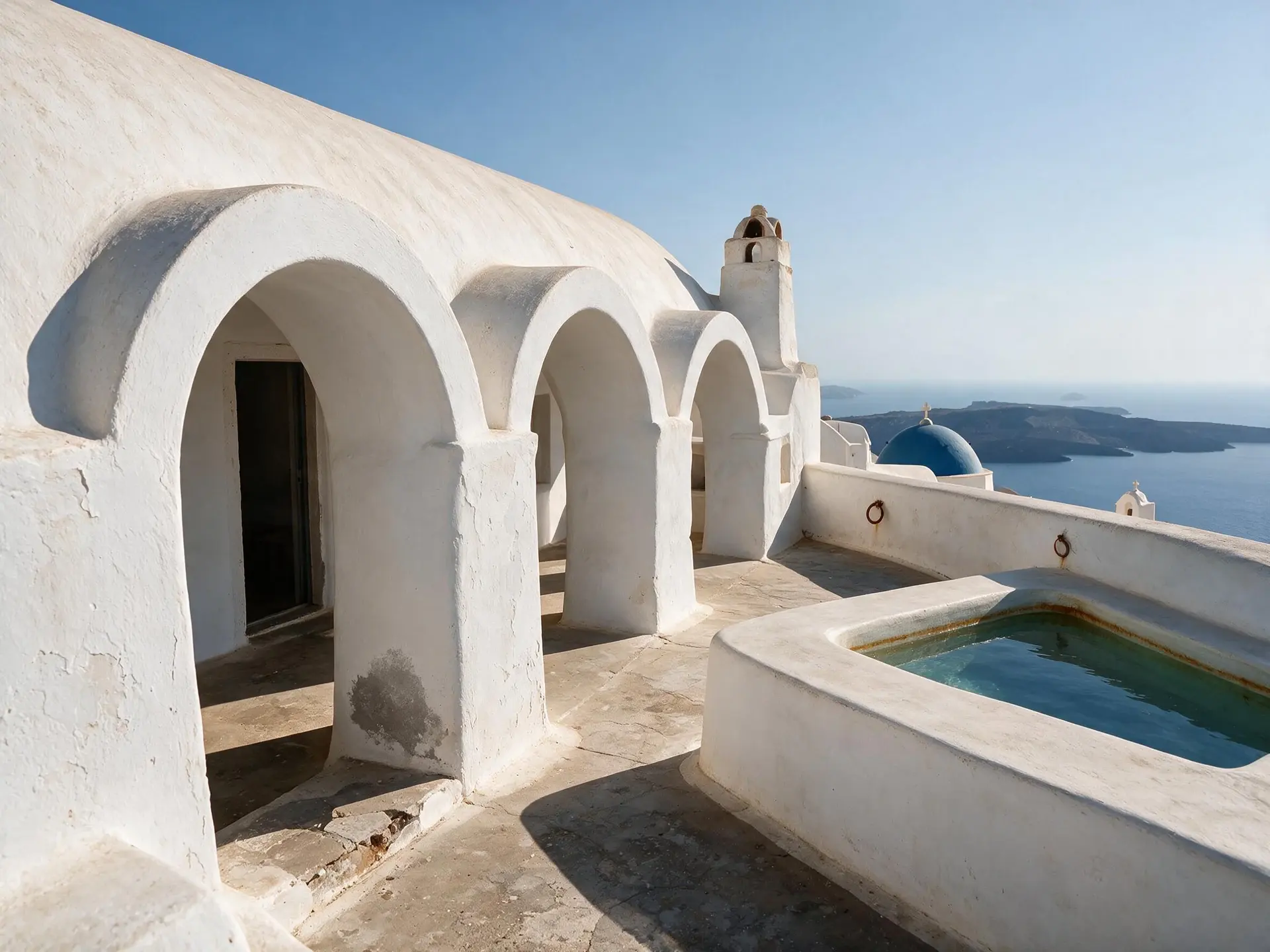 Before and after of a barrel-vaulted caldera house terrace in Oia, Santorini.