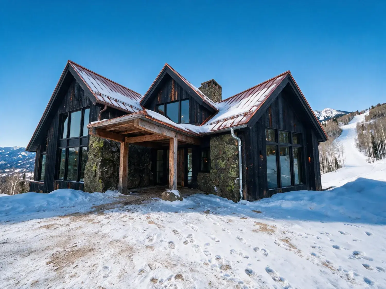 Before and after of a red mountain ski estate of blackened timber and drystone rises from powder snow, the existing rockies behind it resolving into crisp alpine clarity — enhanced by Plotpane