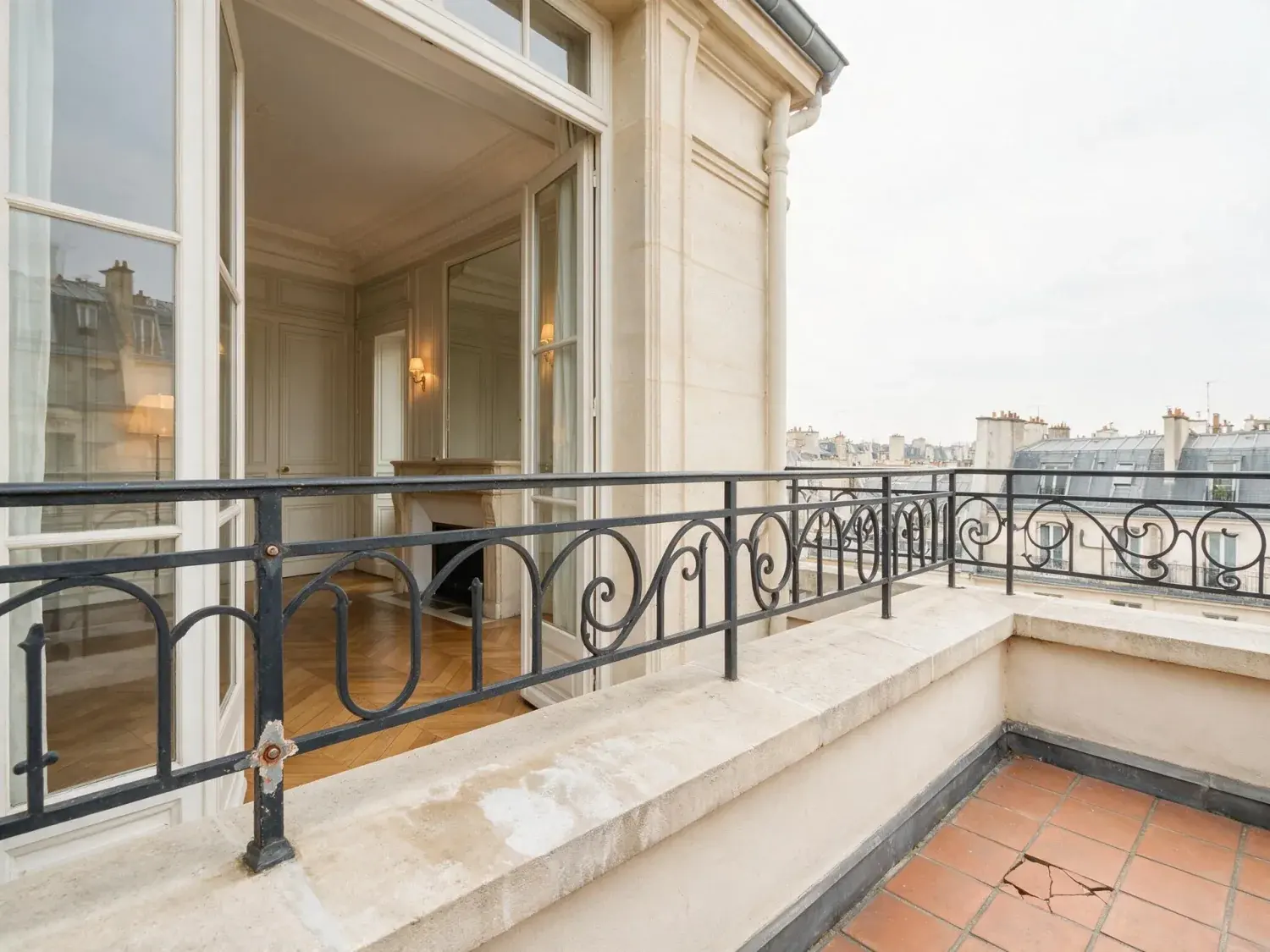 Before and after of a haussmannian penthouse on avenue montaigne slides from afternoon into a paris blue hour, its zinc-roof horizon studded with existing landmarks waking up — original listing photo before editing
