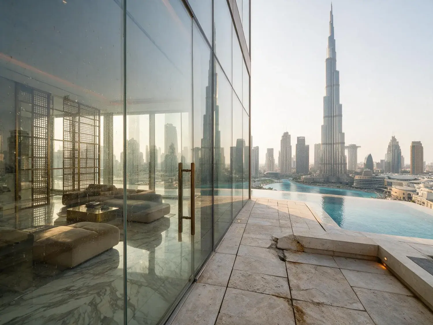 Before and after of a sculpted full-floor penthouse balcony frames the burj khalifa spire as the desert dusk turns the glass canyon molten amber — original listing photo before editing