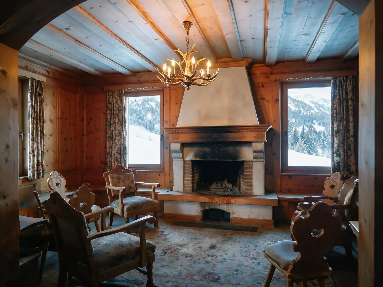 Before and after of a dated st moritz chalet salon is reimagined as a contemporary alpine sanctuary of blackened timber, raw stone and ivory shearling — enhanced by Plotpane