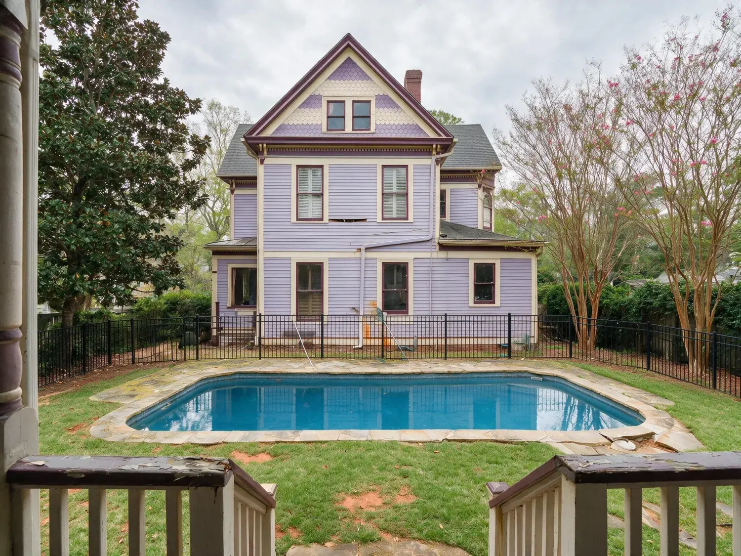 Before and after of a restored 1890s inman park queen anne victorian with an algae-clouded gunite pool and pollen-yellowed lawn — reborn as an emerald zoysia carpet and resort-blue pool — enhanced by Plotpane