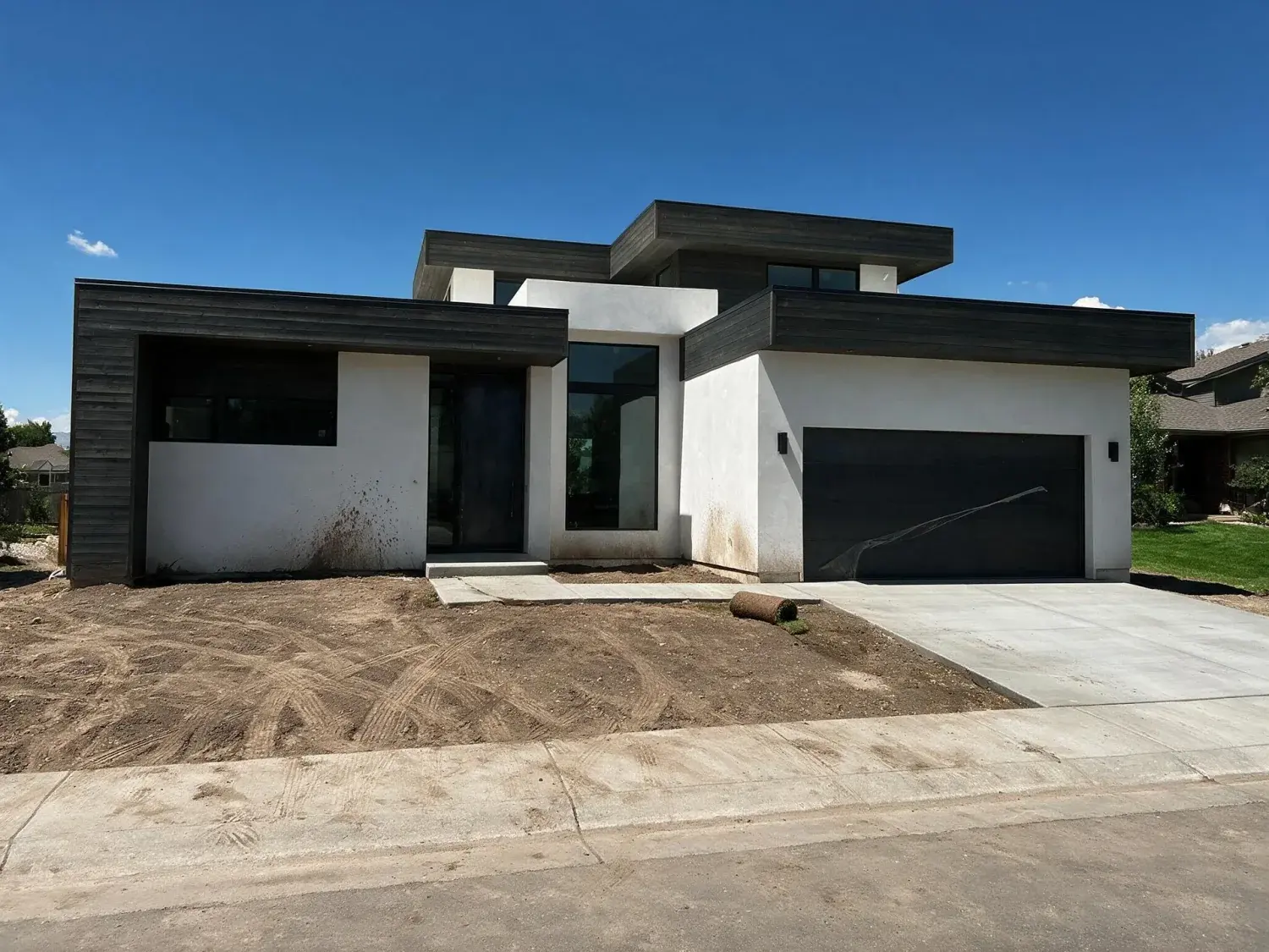 Before and after of a freshly topped-out cherry creek contemporary in its ugly-duckling construction-site phase — pulled into a clean, polished marketing hero before the sod is even laid — original listing photo before editing