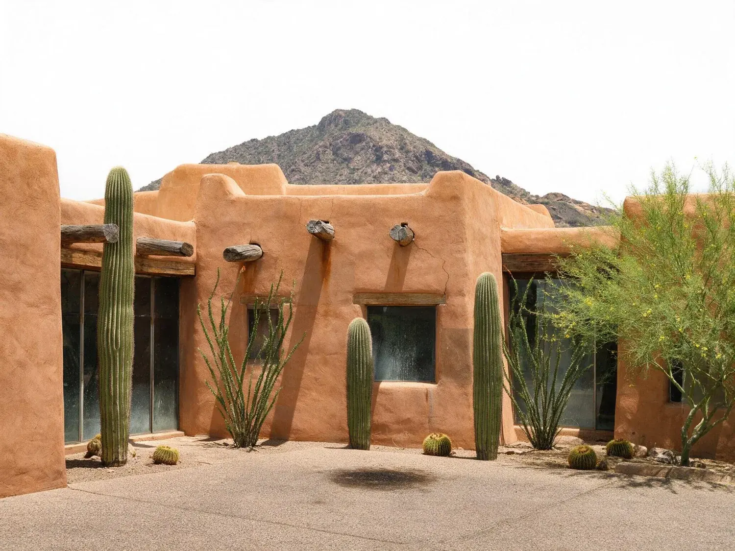 Before and after of a rammed-earth and adobe paradise valley estate under a bleached arizona noon — reset against a sonoran cerulean with saguaro-perfect edges — original listing photo before editing