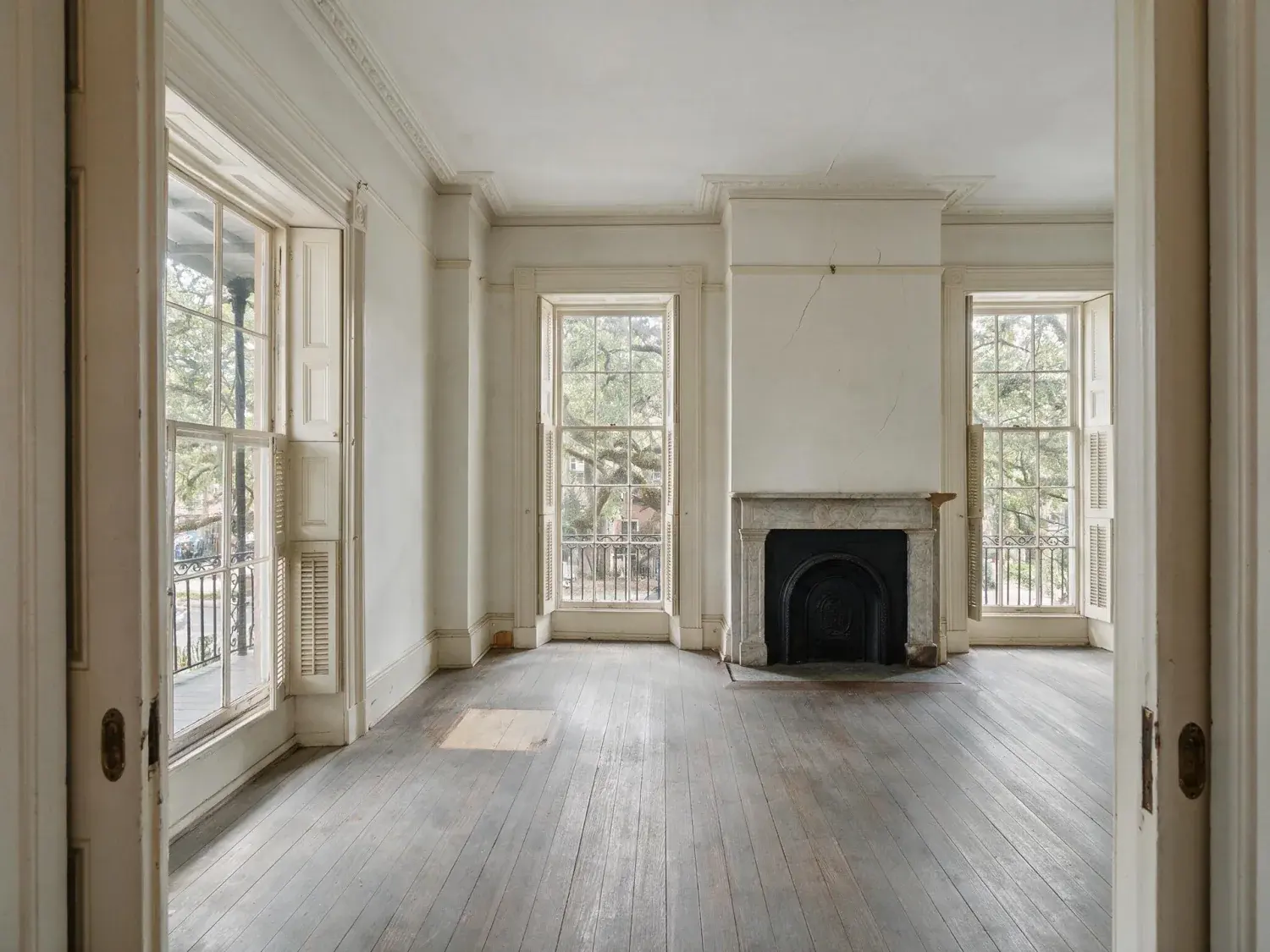 Before and after of a federal-era savannah rowhouse parlor on monterey square — an empty heritage shell that'll sit 73% longer on market unstaged, transformed into a scroll-stopping mls hero — original listing photo before editing