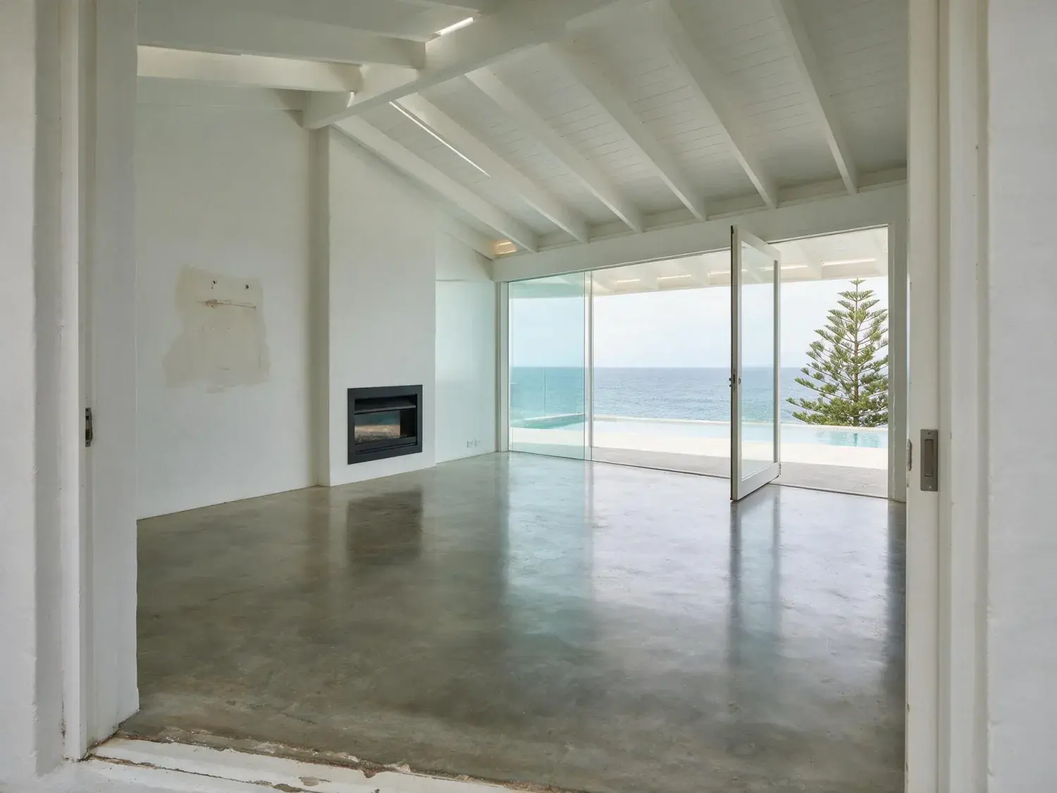 Before and after of a white-stucco bondi cliff-top modernist with a full wall of ocean glass — empty for auction campaign photos and staged into the exact domain / realestate.com.au hero the saturday crowd is scrolling — original listing photo before editing