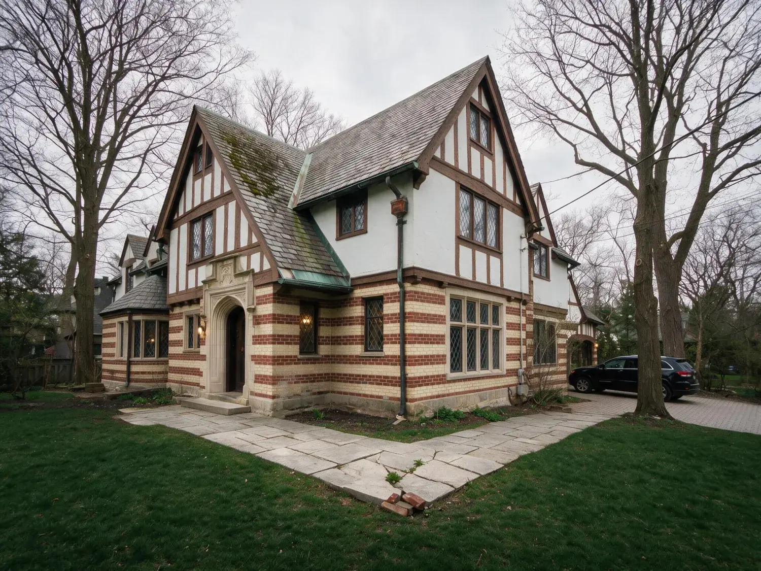 Before and after of a 1920s rosedale tudor-revival estate captured under flat great-lakes overcast, recovered into a realtor.ca / sotheby's canada premium hero — enhanced by Plotpane