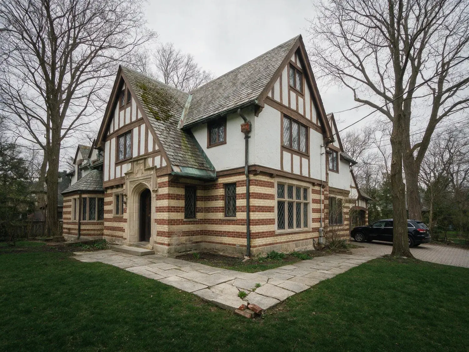 Before and after of a 1920s rosedale tudor-revival estate captured under flat great-lakes overcast, recovered into a realtor.ca / sotheby's canada premium hero — original listing photo before editing