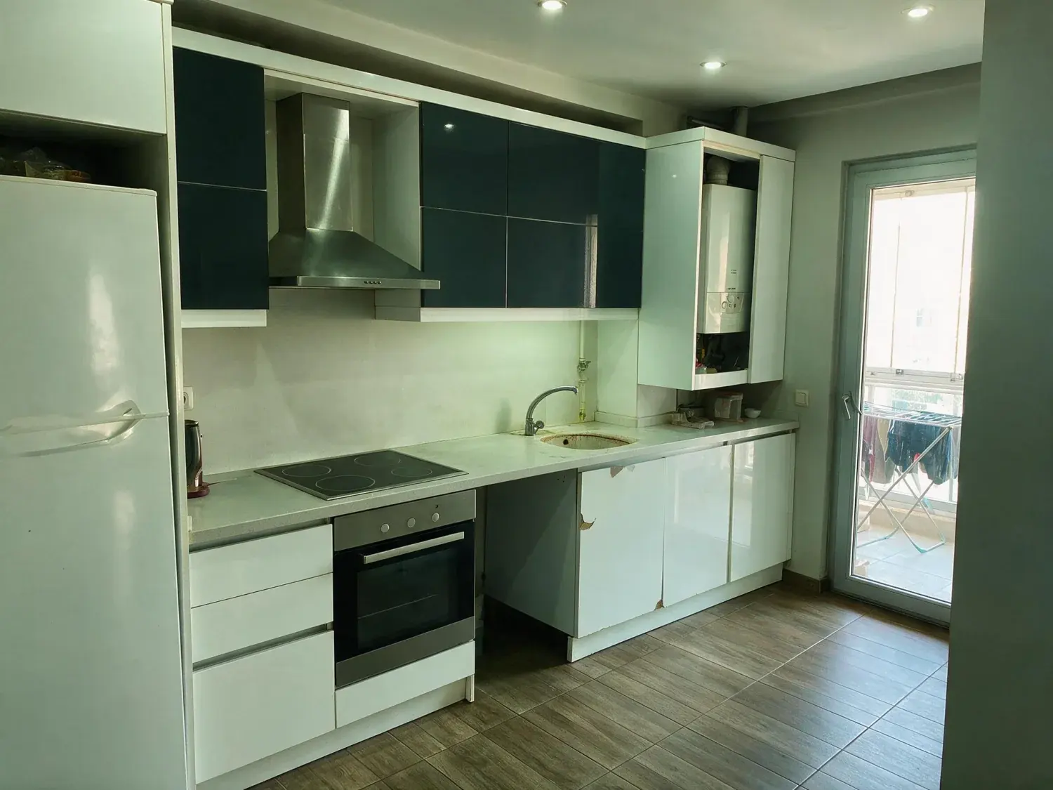 Before and after of a lived-in kitchen in an ataşehir residence tower, with the day's dishes, bottles and water carboy named for removal