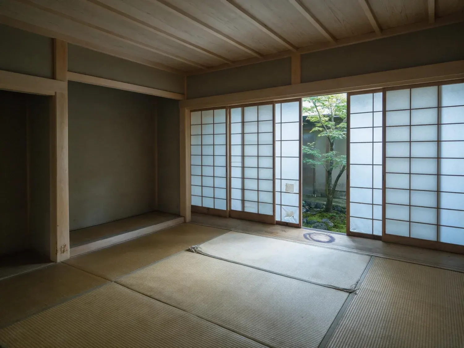 Before and after of a serene kyoto-inspired zen house with tatami and shoji, an empty contemplative shell transformed into a minimalist tea-ceremony retreat — original listing photo before editing