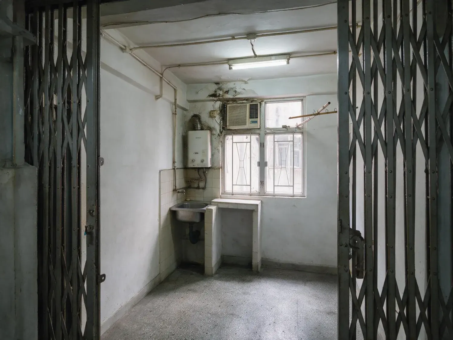 Before and after of a 280 square foot sham shui po flat photographed with the outgoing tenant's laundry rack, cartons and stools still standing in it — enhanced by Plotpane