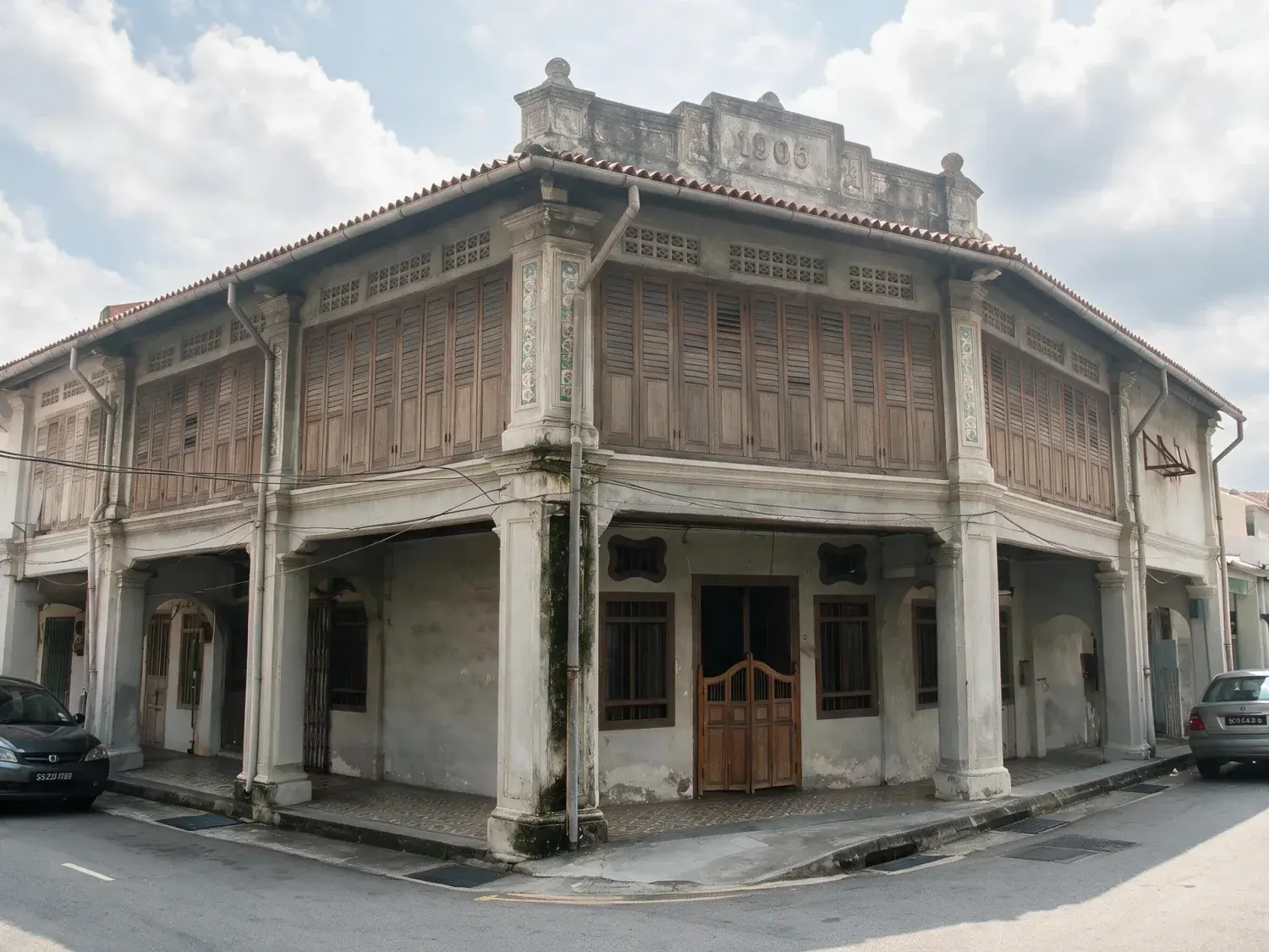 Before and after of a joo chiat shophouse facade shot under the flat white haze singapore has most middays, with no detail left in the sky at all — enhanced by Plotpane