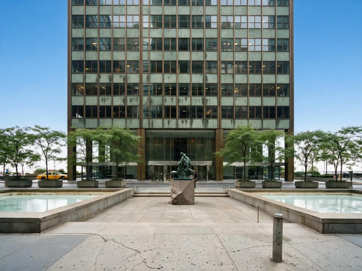 Before and after of a midtown manhattan class-a office tower sheds an oppressive grey-white overcast for a clear blue broker-brochure sky — enhanced by Plotpane