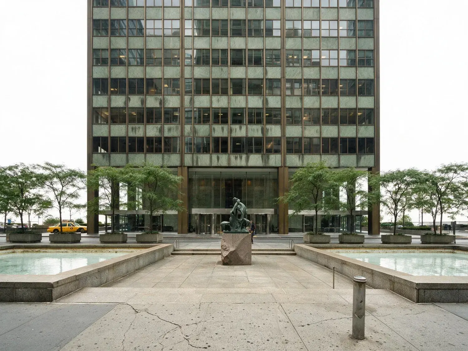 Before and after of a midtown manhattan class-a office tower sheds an oppressive grey-white overcast for a clear blue broker-brochure sky — original listing photo before editing