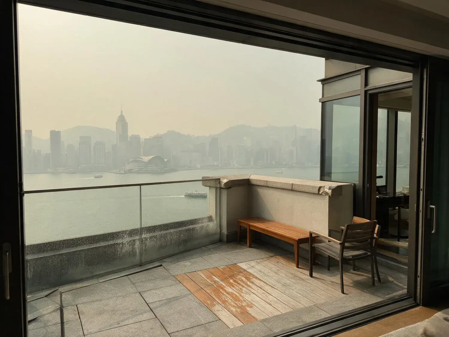Before and after of a rosewood hong kong harbour suite window pivots from smog-grey oppressive haze to a clear, wind-scrubbed dusk over victoria harbour — original listing photo before editing