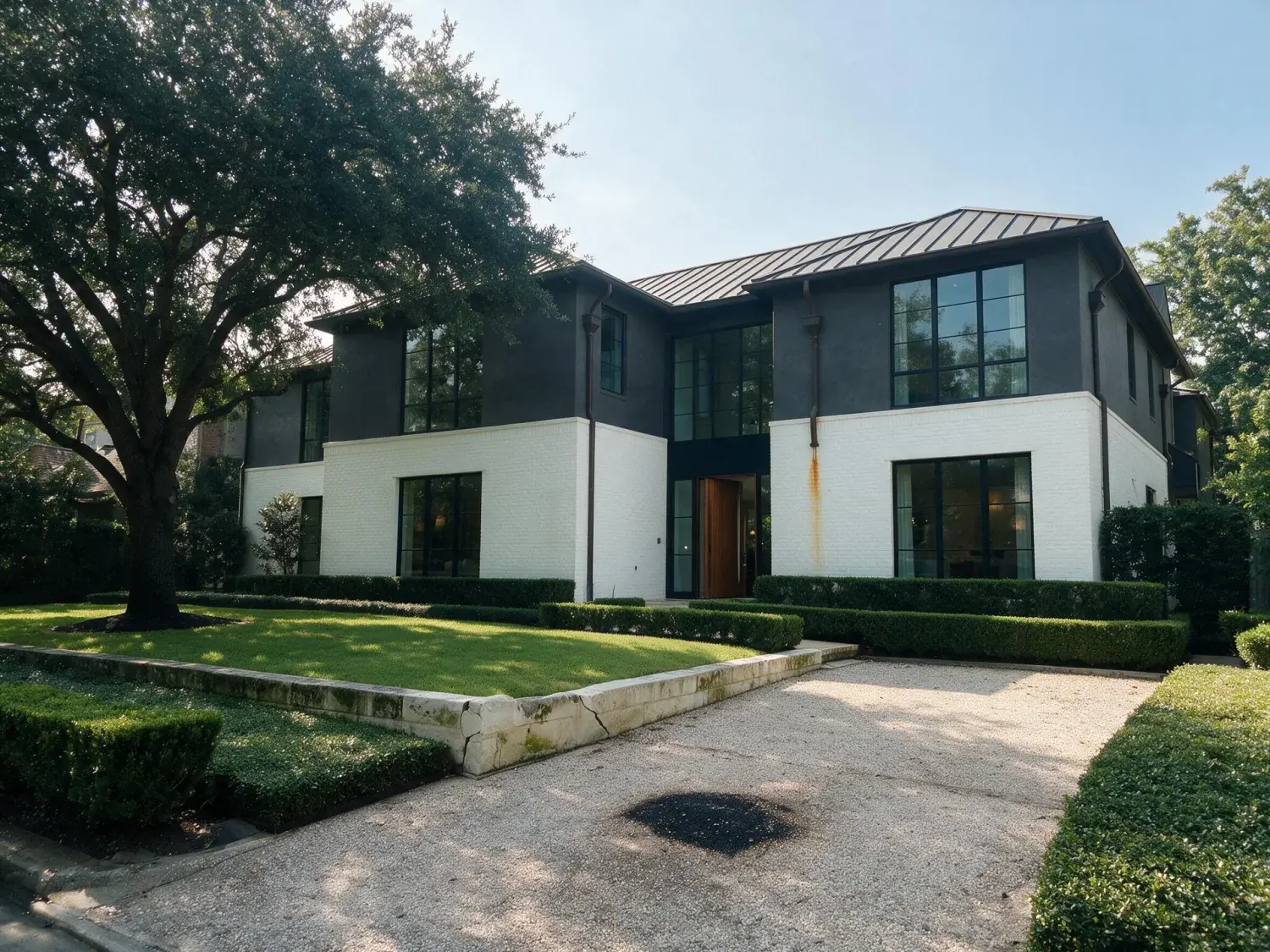 Before and after of front exterior of a river oaks houston modern estate corrected for humidity haze, shadow-highlight range, and color cast — enhanced by Plotpane
