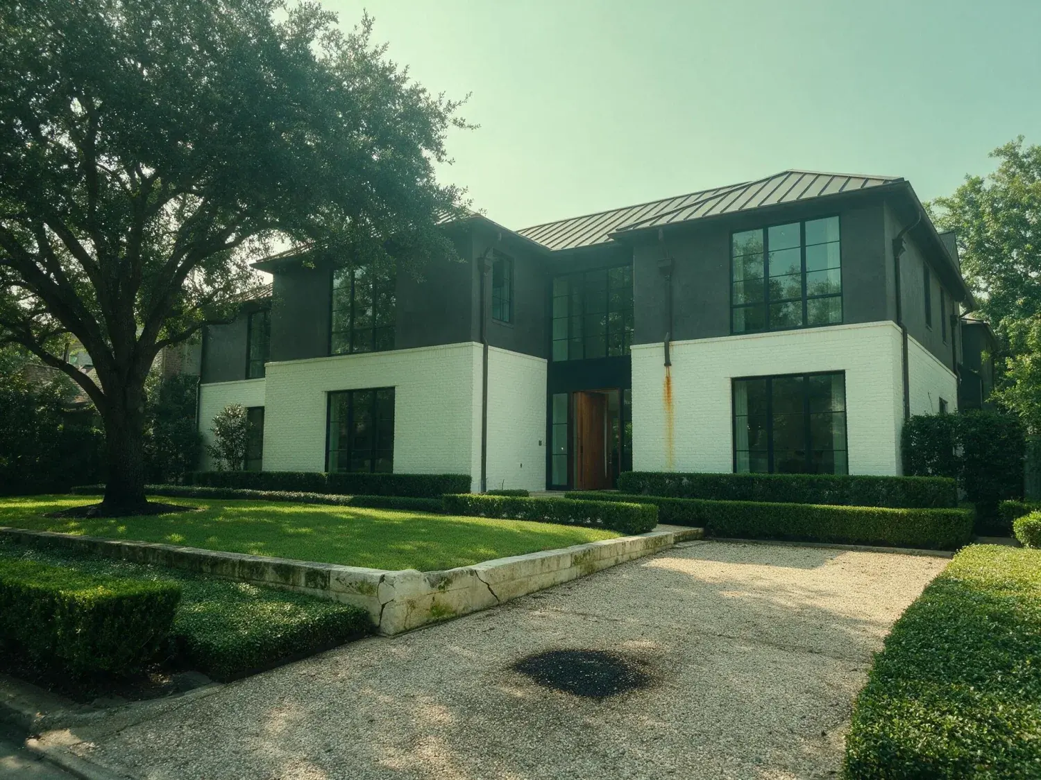 Before and after of front exterior of a river oaks houston modern estate corrected for humidity haze, shadow-highlight range, and color cast — original listing photo before editing
