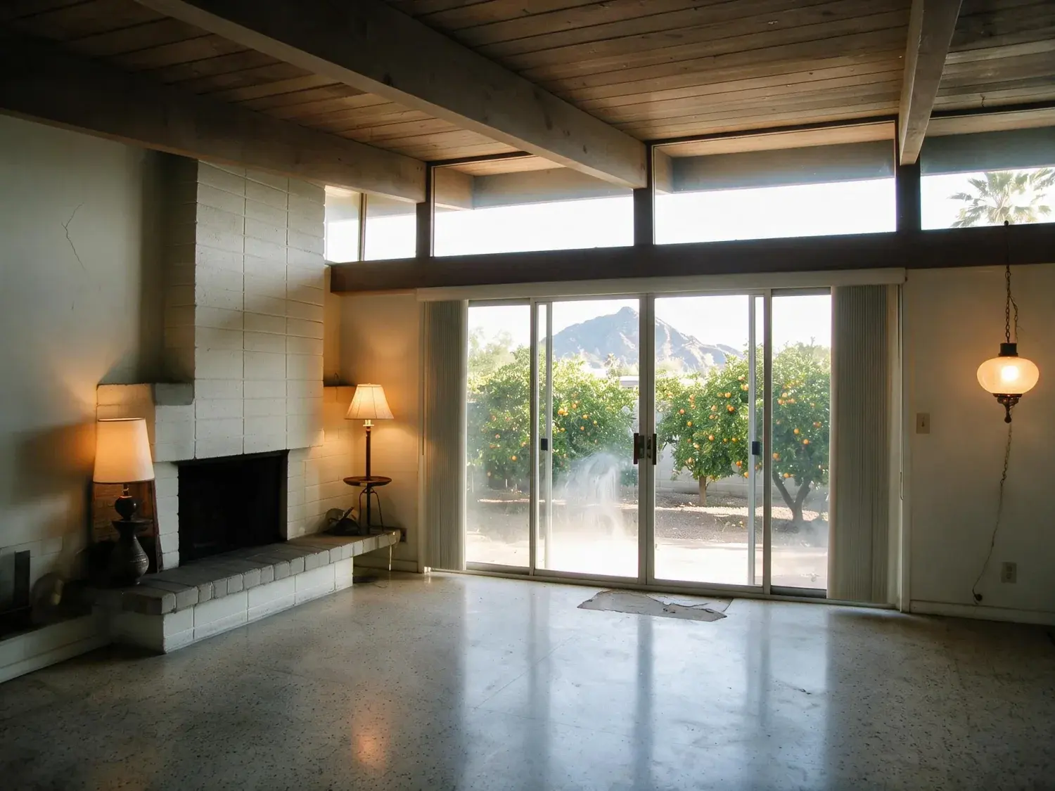 Before and after of an Arcadia ranch living room, dim inside against harsh desert glare outside. — enhanced by Plotpane