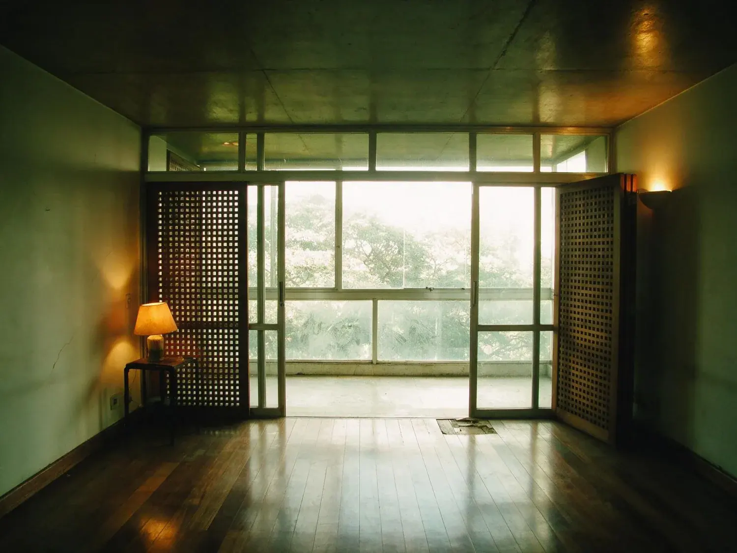 Before and after of a Jardins apartment, dim with the varanda glazing blown out. — original listing photo before editing