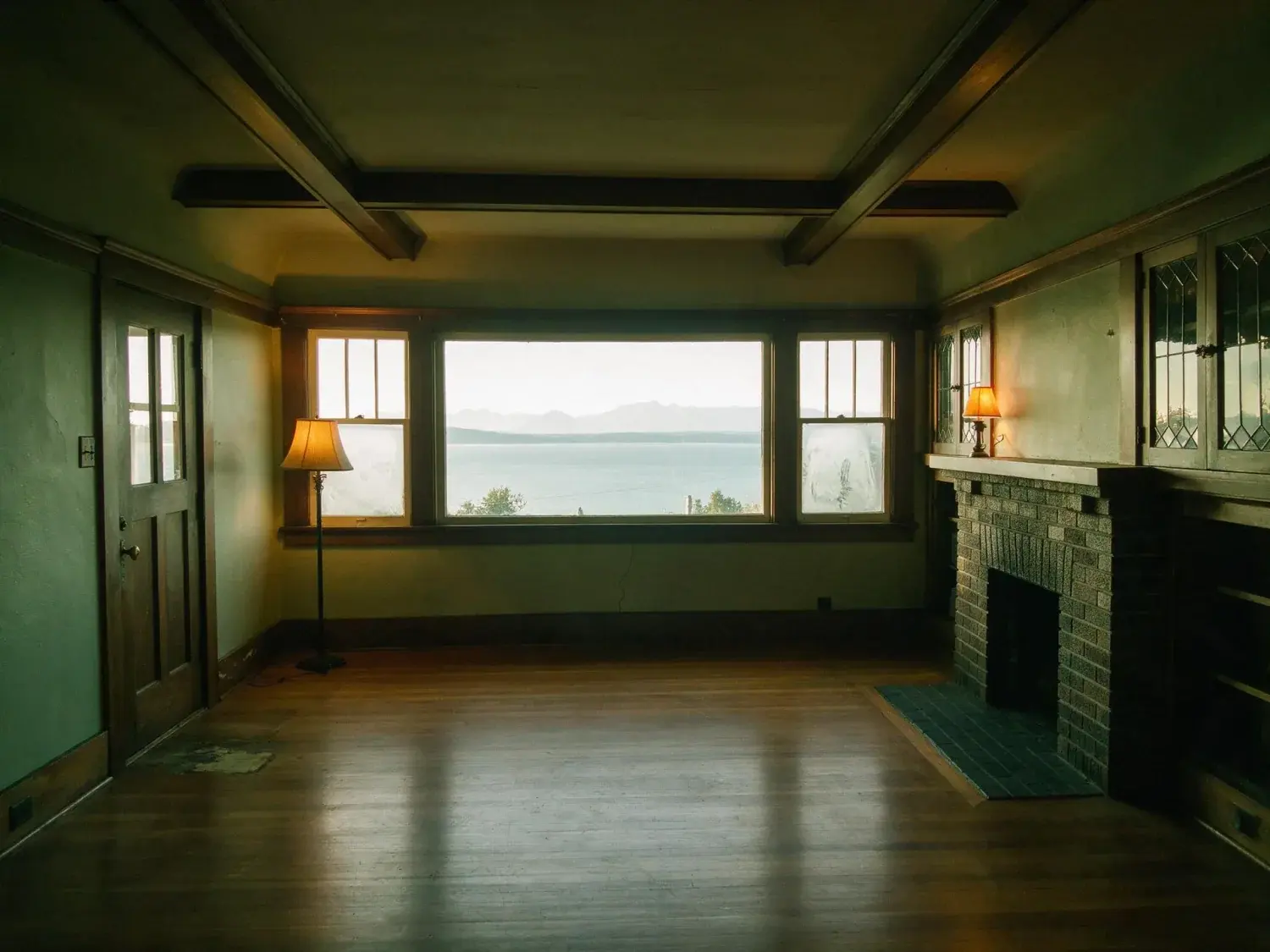 Before and after of a Queen Anne Craftsman room, grey and flat with the bay glare unmanaged. — original listing photo before editing