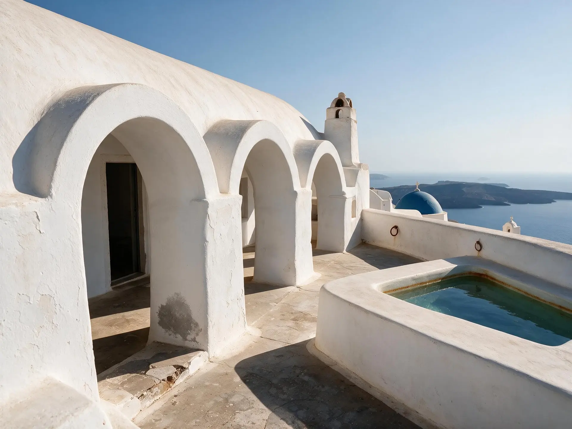 Before and after of a barrel-vaulted caldera house terrace in Oia, Santorini.