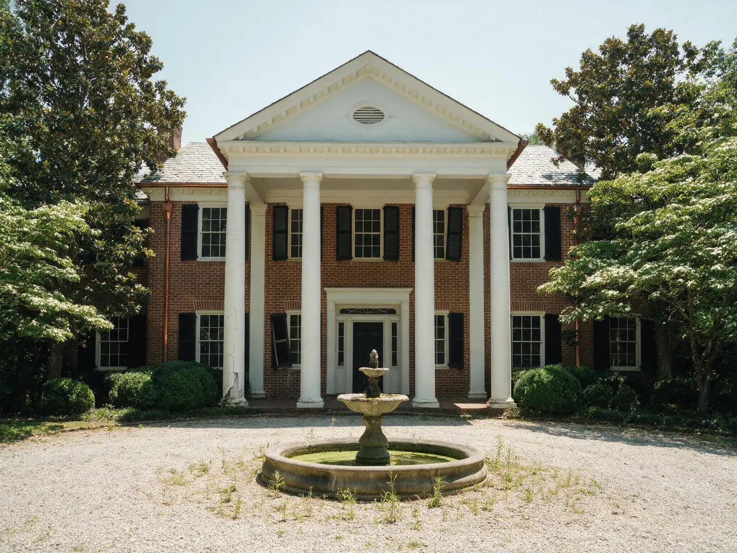 Before and after of a red-brick buckhead plantation-style estate with white columns and magnolia canopy, traded from flat georgia noon to a glowing amber-windowed twilight — original listing photo before editing