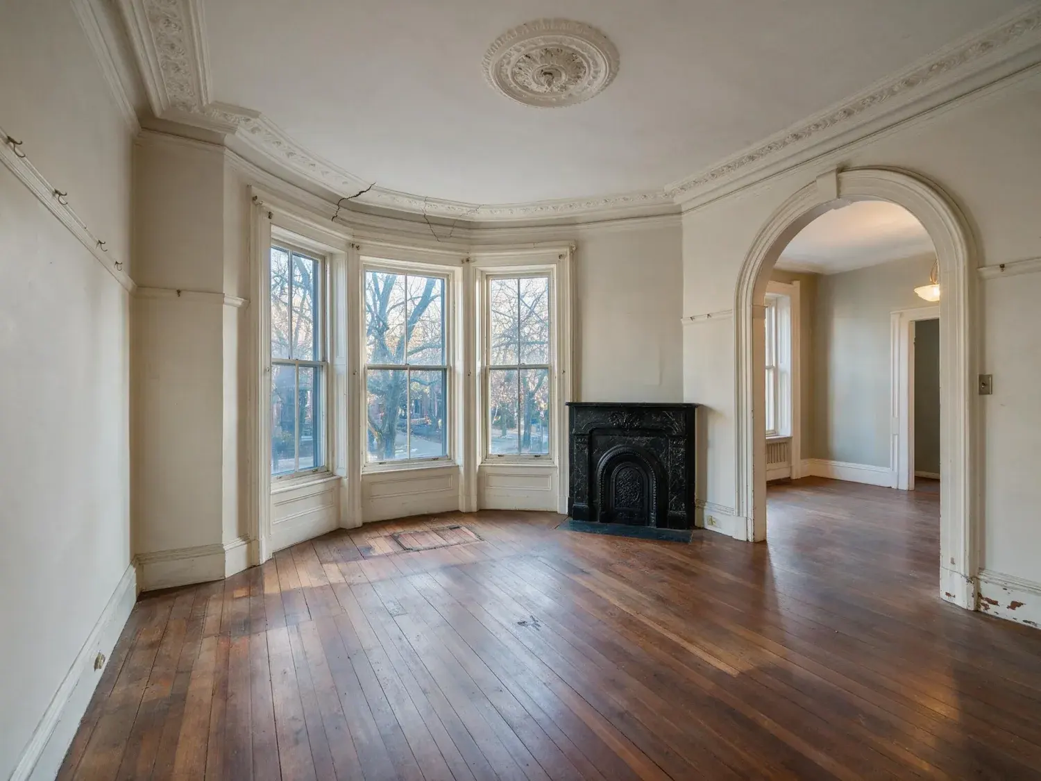 Before and after of a south end boston victorian bowfront parlor with bay windows and original plasterwork — the exact listing that boxbrownie charges $32 per room for, staged here in ~90 seconds at 4k — original listing photo before editing