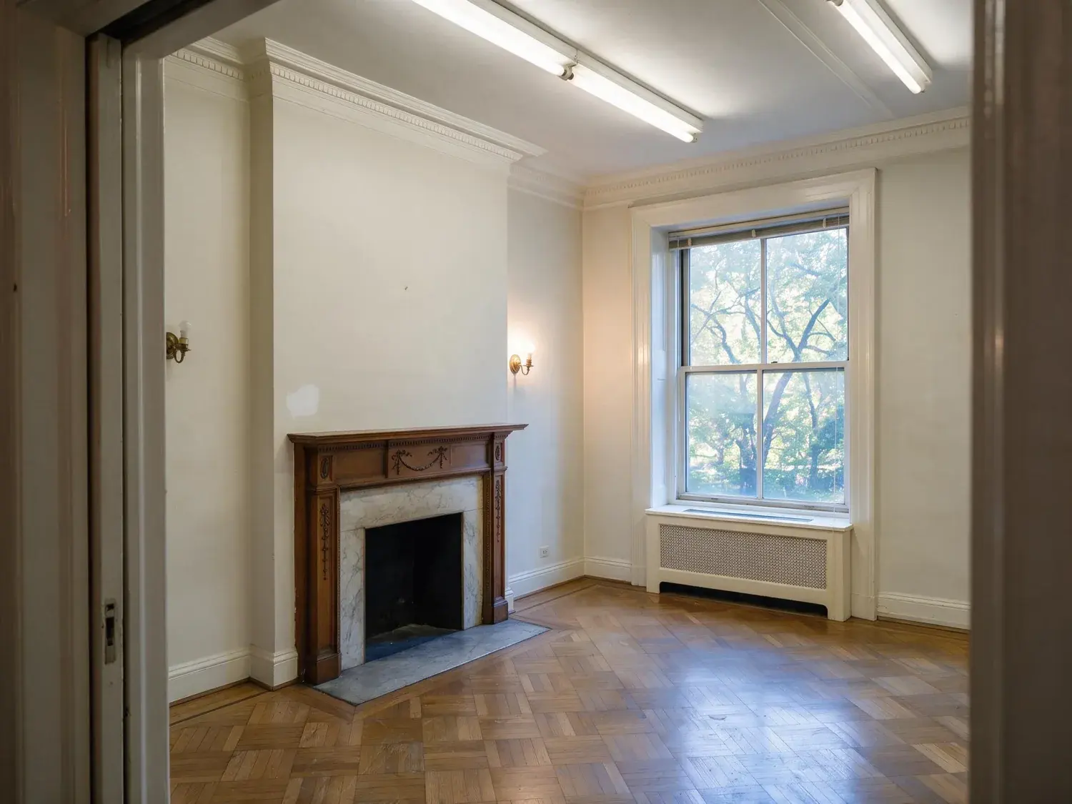 Before and after of a rittenhouse square prewar co-op unit between tenants, a leasing-office phone shot in fluorescent haze restored to marketing-grade apartments.com hero — enhanced by Plotpane