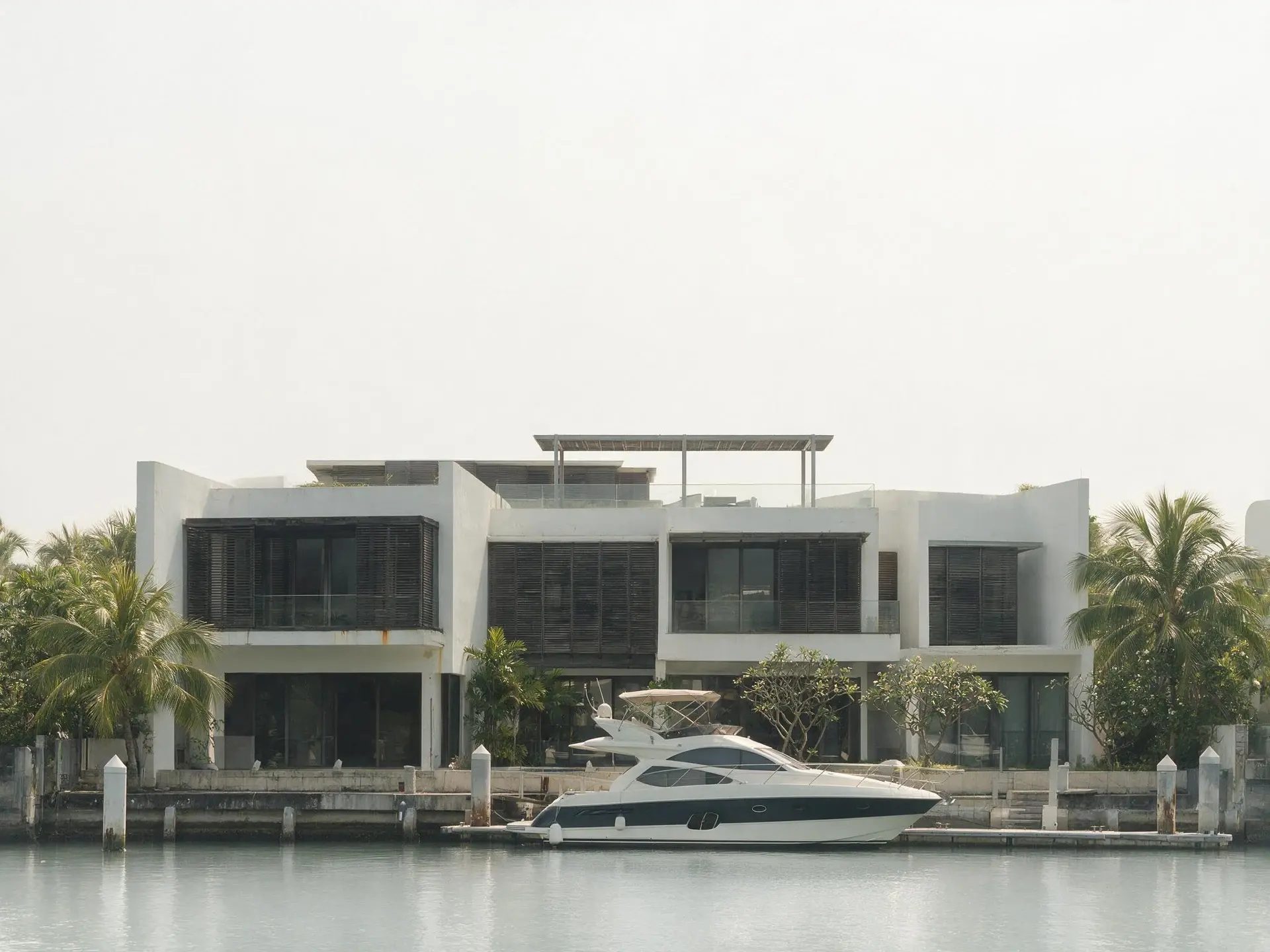 Before and after of a waterfront bungalow with a private berth at Sentosa Cove, Singapore. — original listing photo before editing