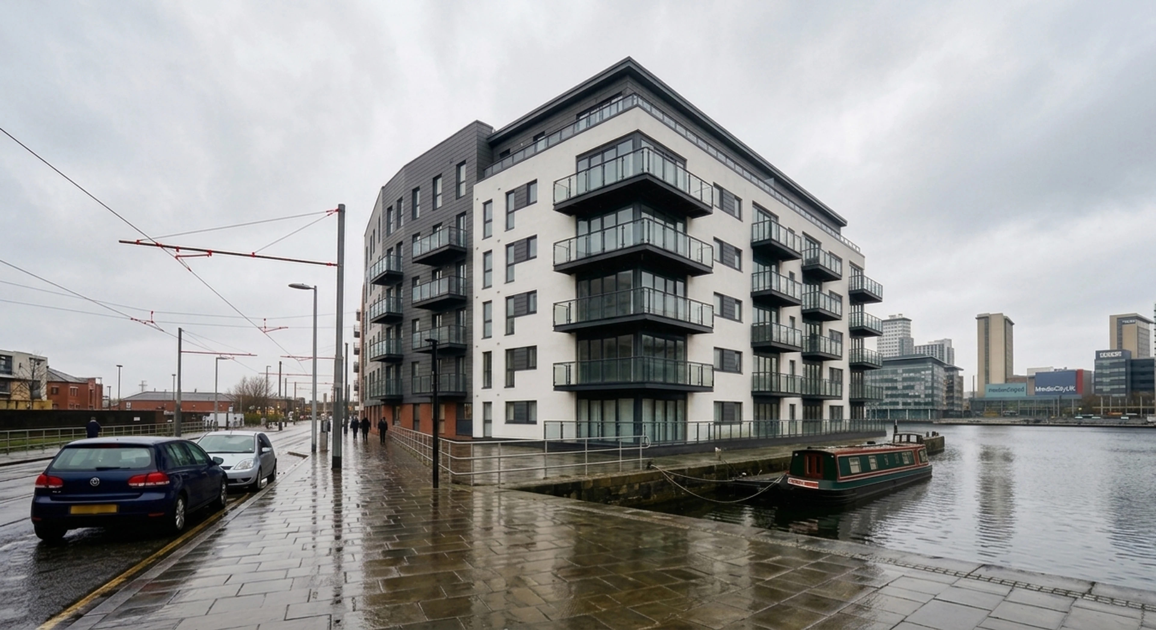 A Salford Quays waterfront modernist apartment block captured under flat Pennine overcast — recovered into a Rightmove premium hero. — enhanced by Plotpane