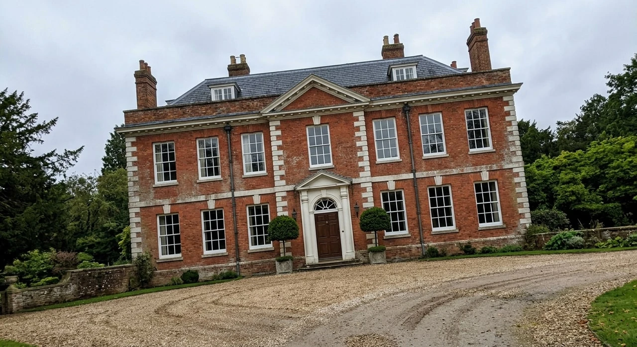 A five-bay Georgian manor, its classical symmetry restored after a careless handheld tilt flattened its grandeur. — original listing photo before editing